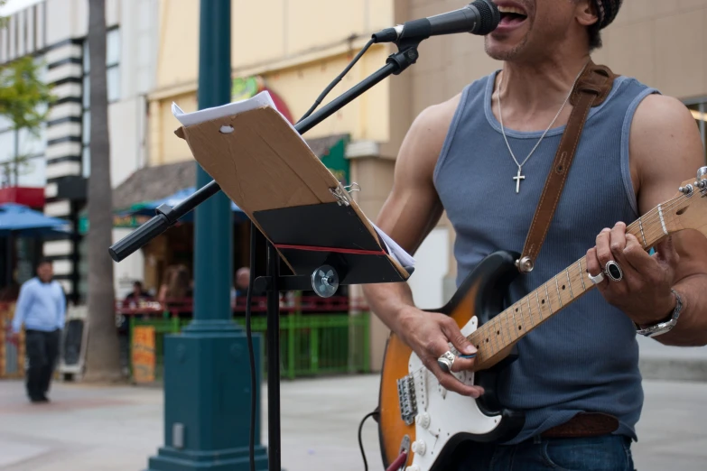 a man standing in front of a microphone playing guitar