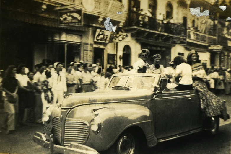 old time po of a car being driven by women in the city