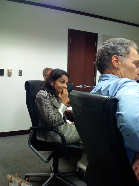 an old man with glasses sits in front of a woman