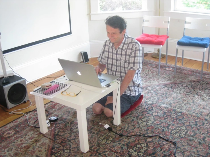 a man sitting at his desk using his laptop