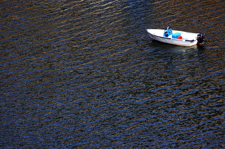 a small white boat floating in a body of water