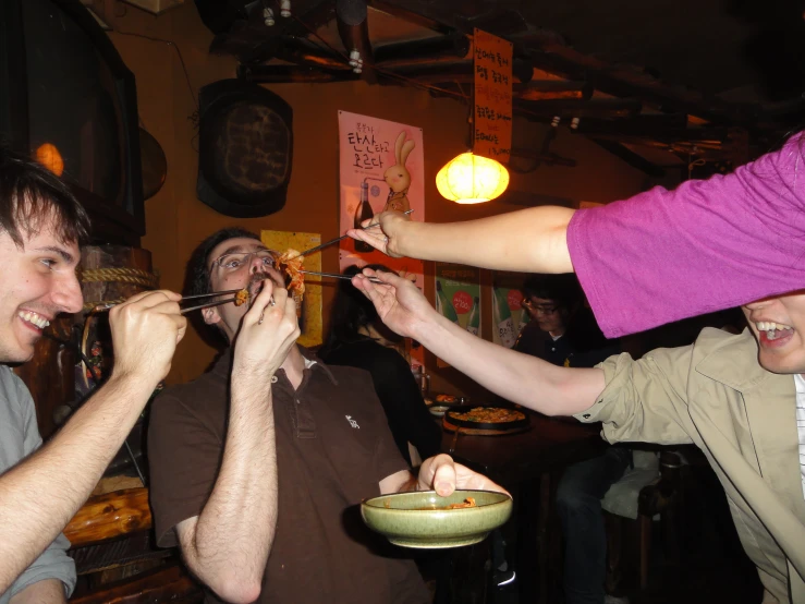 people standing around eating and drinking drinks