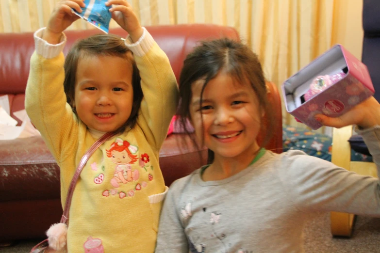 two children, one girl holding up a blue object