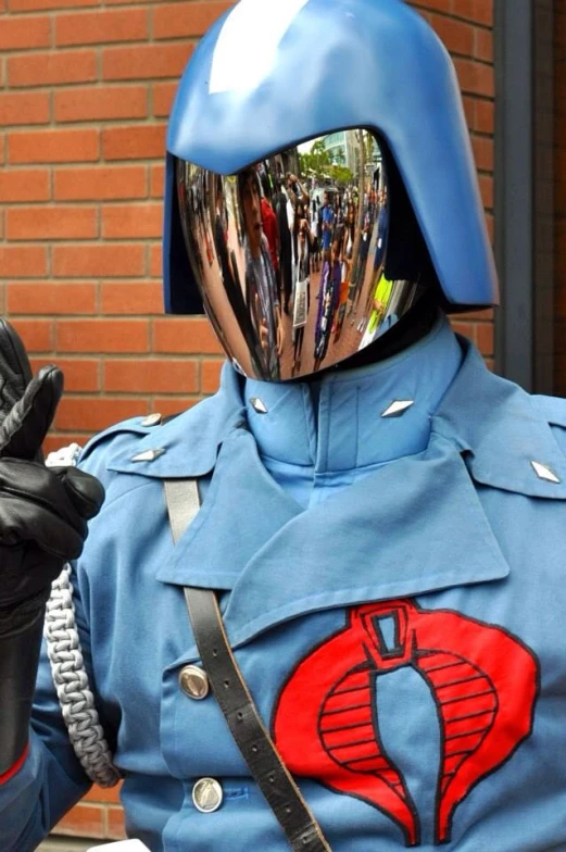 man dressed as co in street costume, with his fingers raised