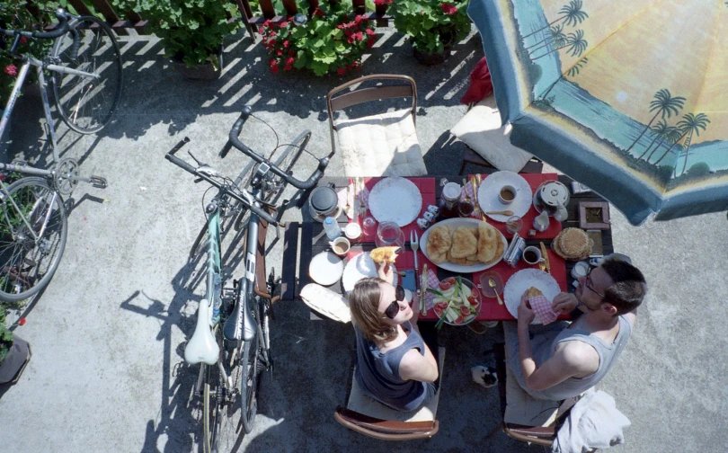 some people are sitting at a table in front of a bicycle