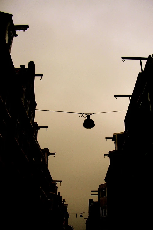 a view of an open street with a traffic light and overhead lighting