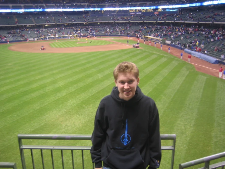 a man is standing on the side of a baseball field