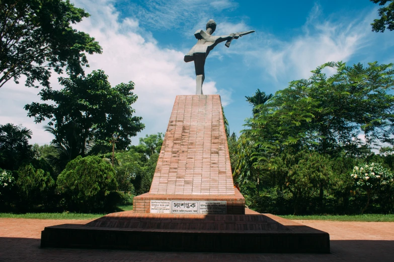 a memorial with a person holding up a umbrella