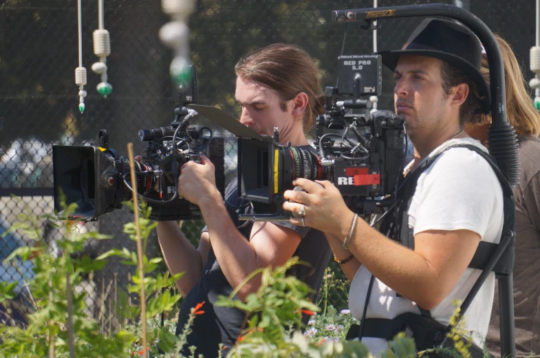 two men are filming on a film set