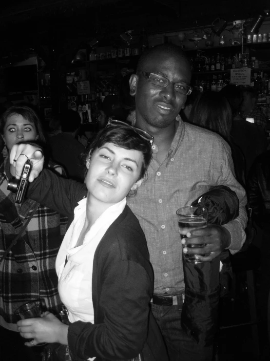 a woman posing for the camera with two men at a bar