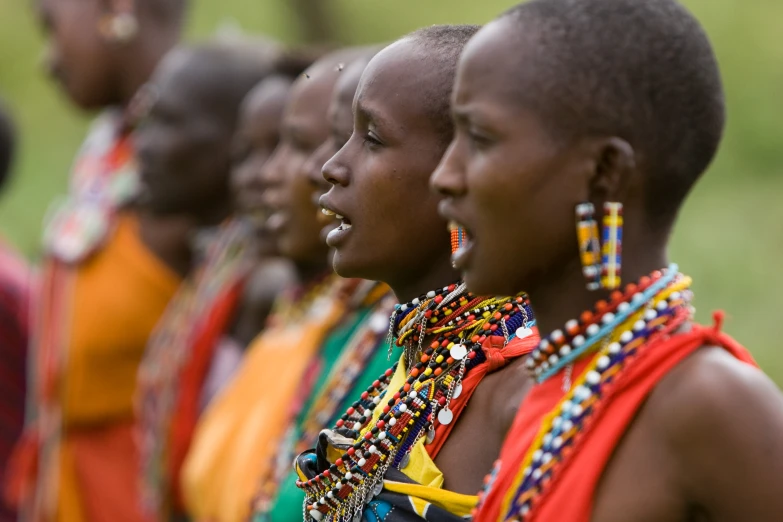 a row of young african girls with beaded necklaces