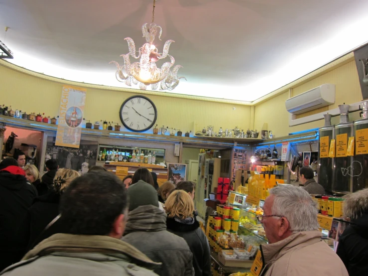 a group of people in a busy market with a clock