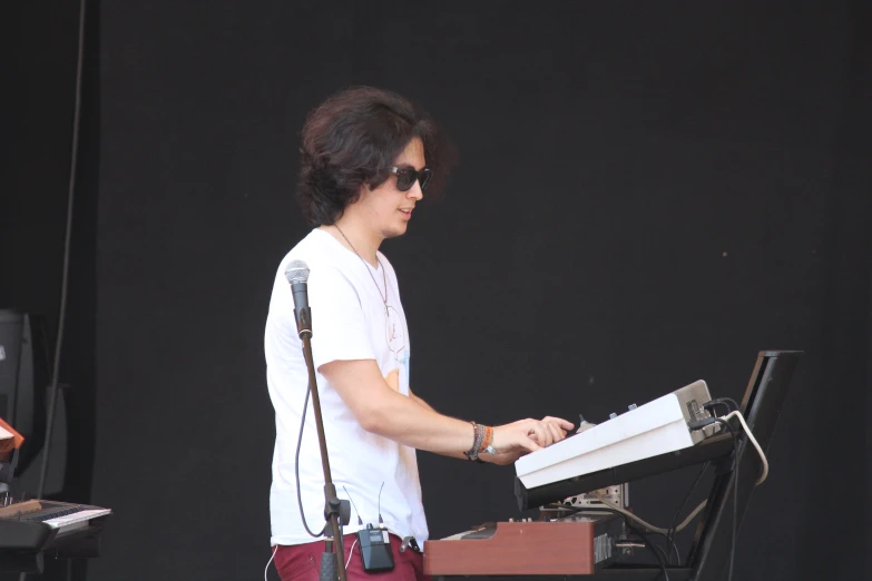 a man standing next to a keyboard at a concert