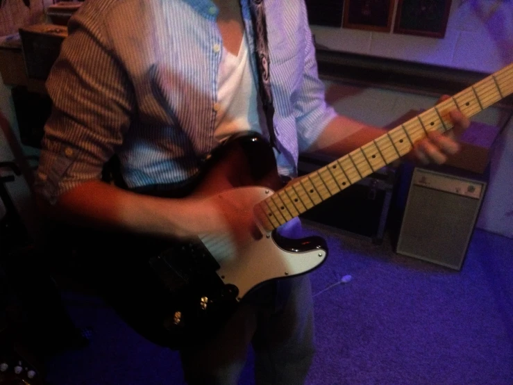 man playing an electric guitar in a room