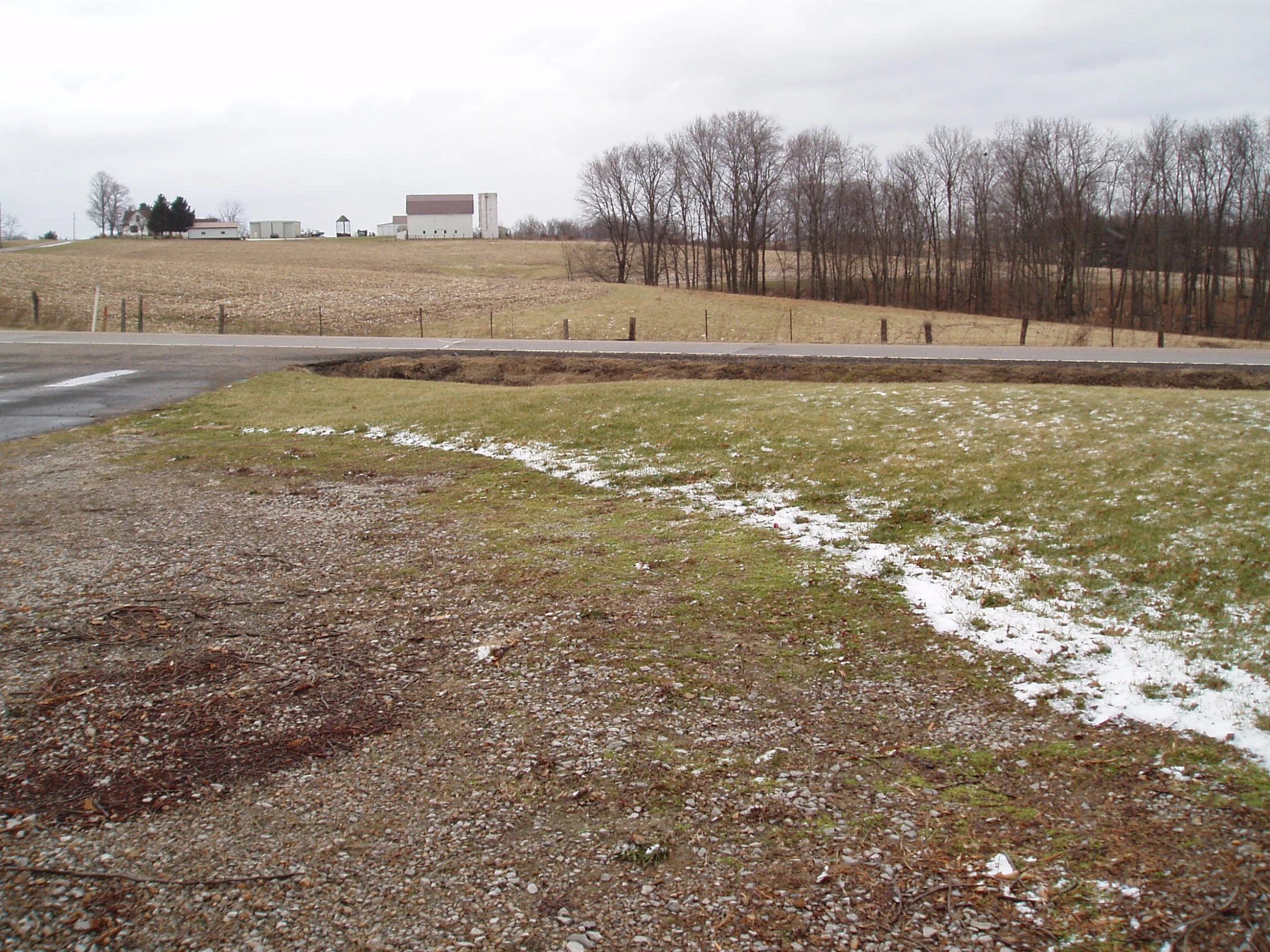 a snow covered field with a small road