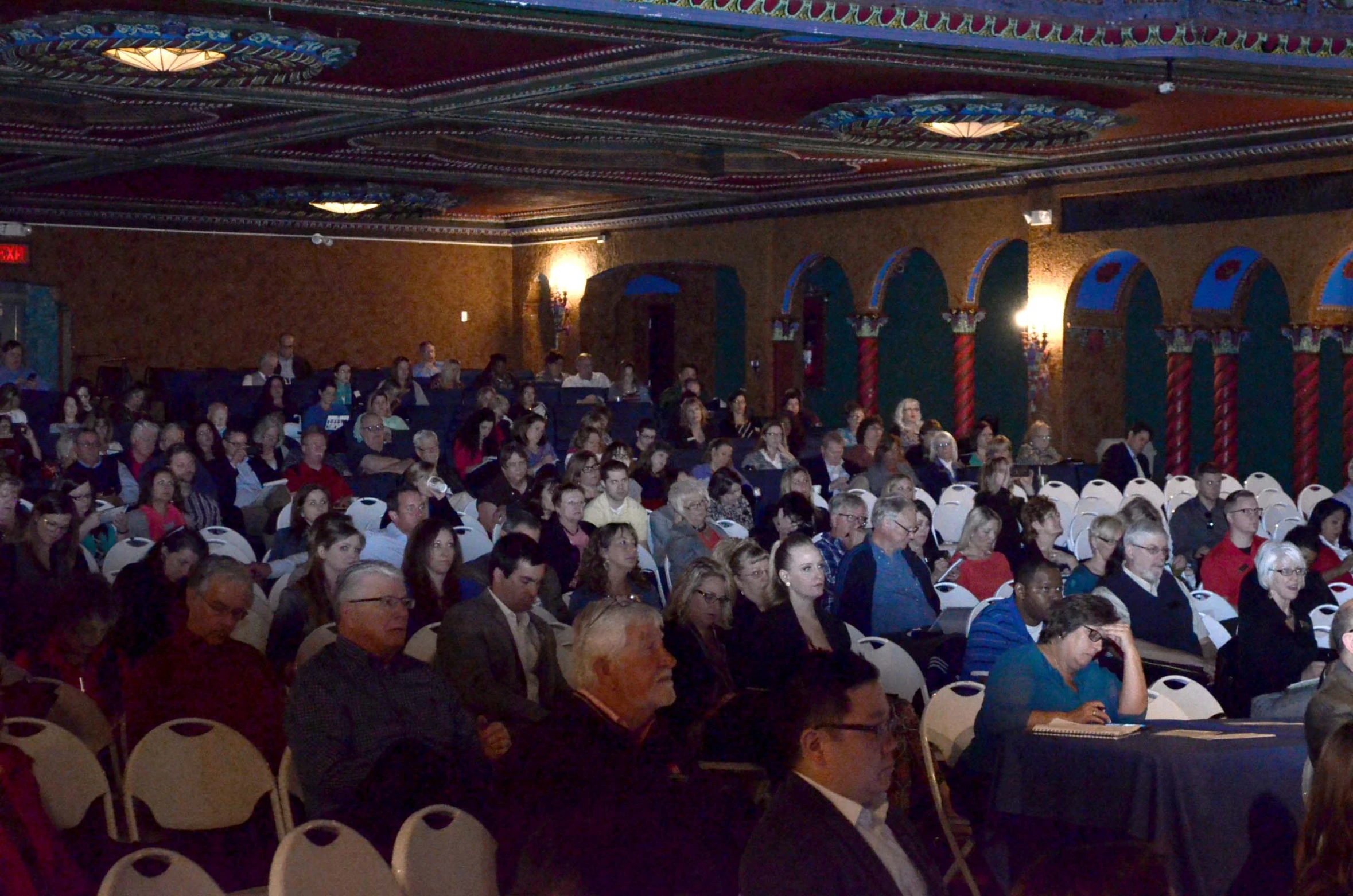 many people in suits and ties seated in rows for a large gathering