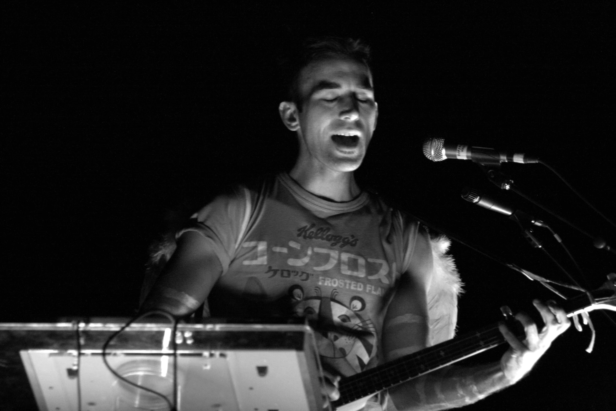 a man that is standing at a mic and holding a guitar