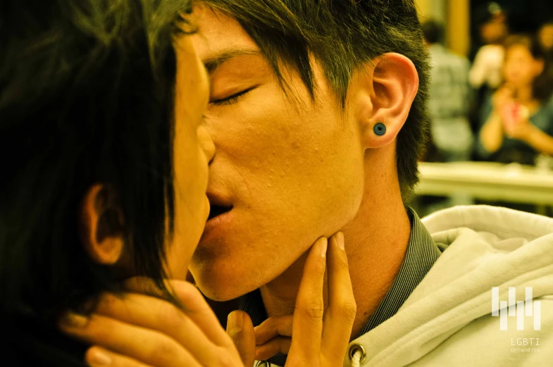 a close up of a person kissing a person on the cheek