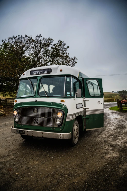 an old fashioned green bus on the side of the road