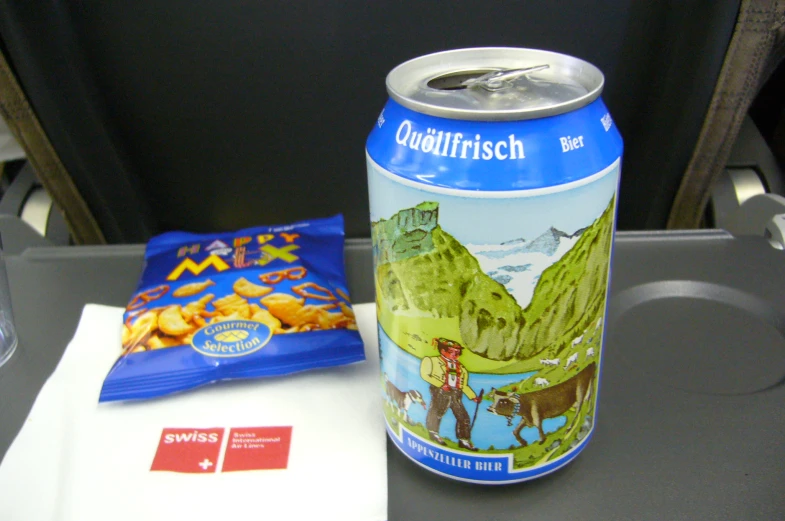 a can of beer with a bag on the table beside it