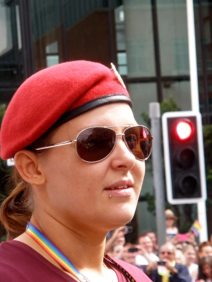 a woman with sun glasses wearing a red hat