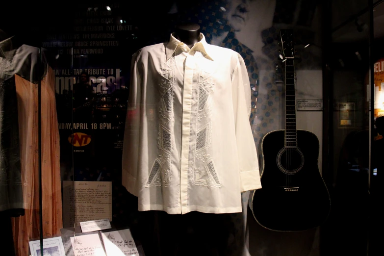 a vintage dress and guitar are on display