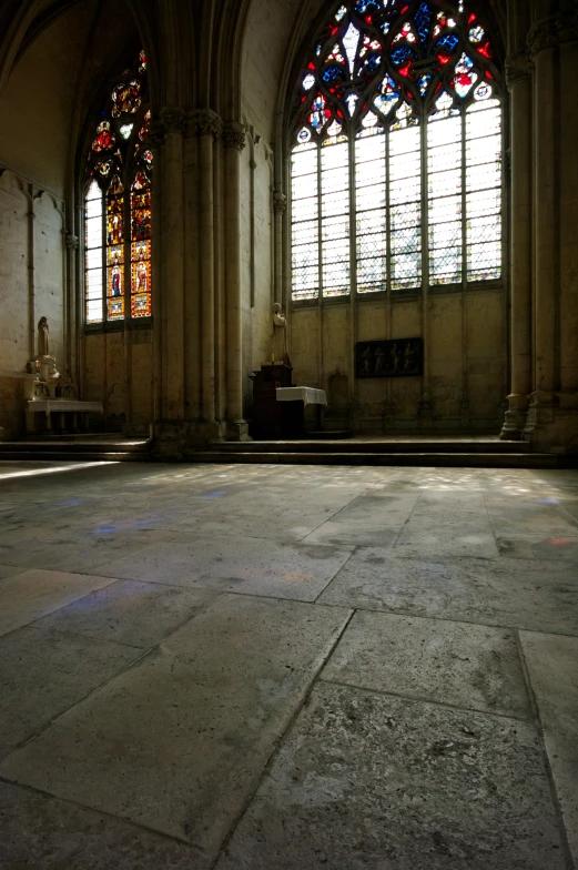 a stone floor that has two stained glass windows