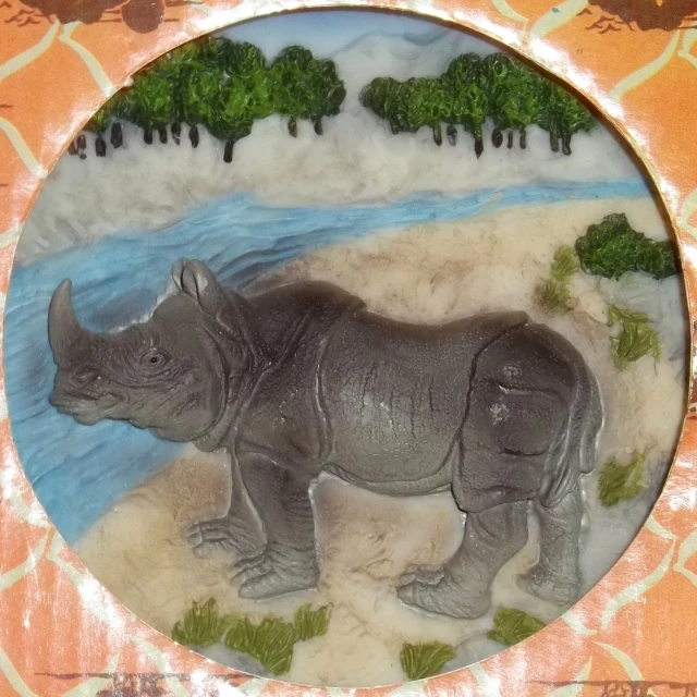 a rhino statue is displayed in a decorative frame