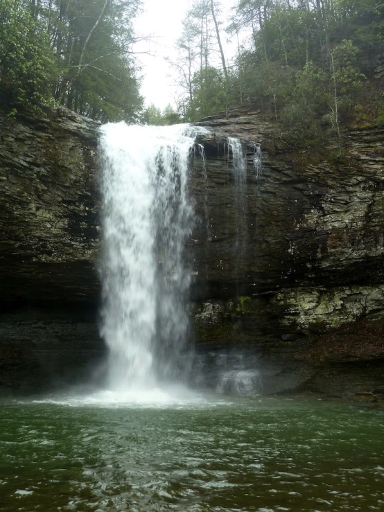 a tall waterfall with water casing the side of it