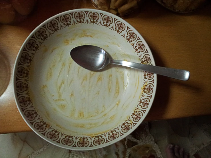 a spoon and a bowl on a wooden table