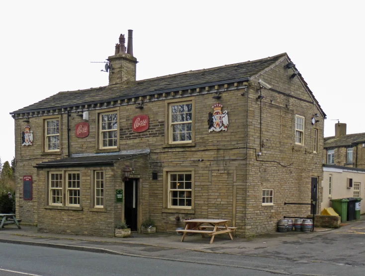 a large old brick building with benches and tables around it