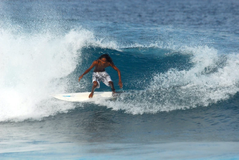 a young man riding a wave on top of a surfboard