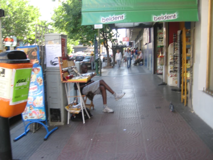 a man sits in a chair in front of an assortment of shoes on the street