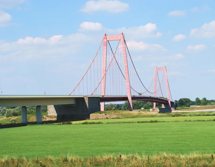 two bridge over a wide open field with grass on both sides