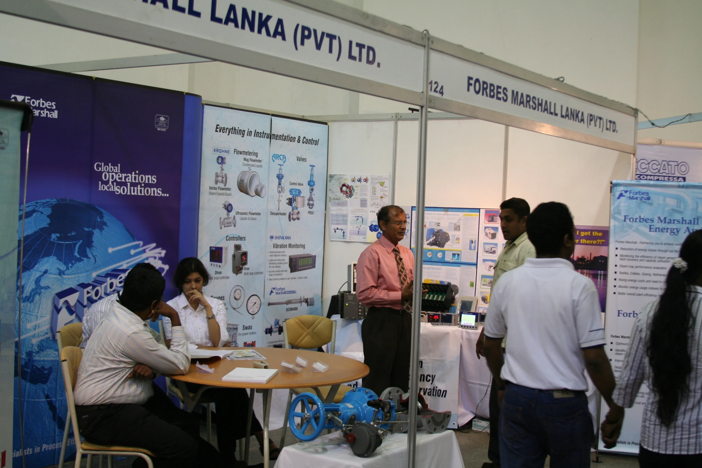 a man is speaking to people at a booth