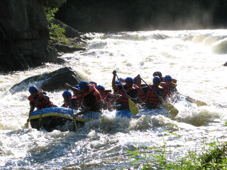 rafts float down rapids on a river in the woods