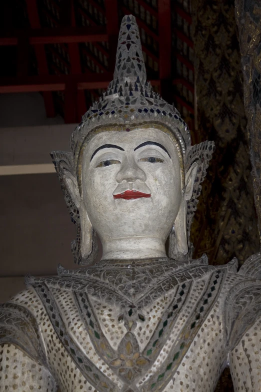 statue with big head and a silver top with beads