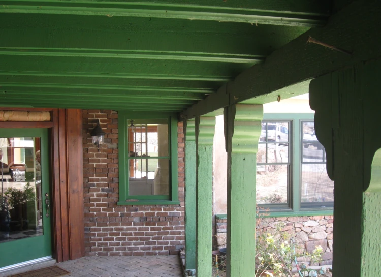 the green building has three glass windows on both sides of it