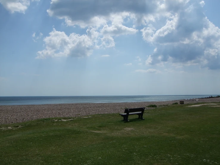 a bench overlooking a beautiful blue beach near the ocean