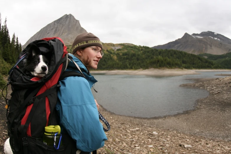 the woman walks her dog through the wilderness