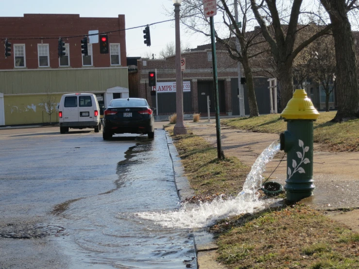 a yellow fire hydrant that is running out of water