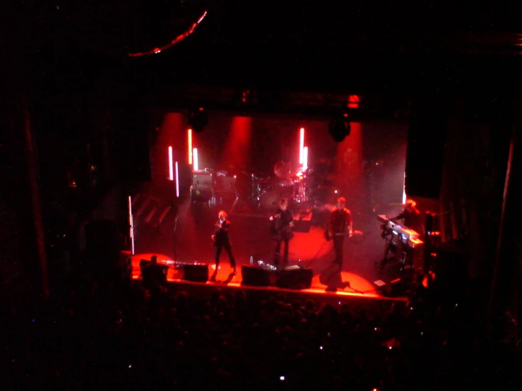 three people playing in the dark on stage