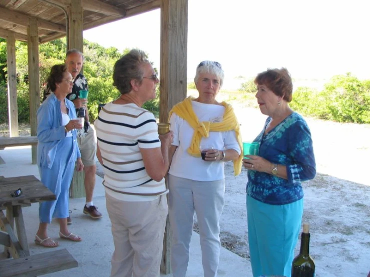 women stand and talk to each other under the shelter