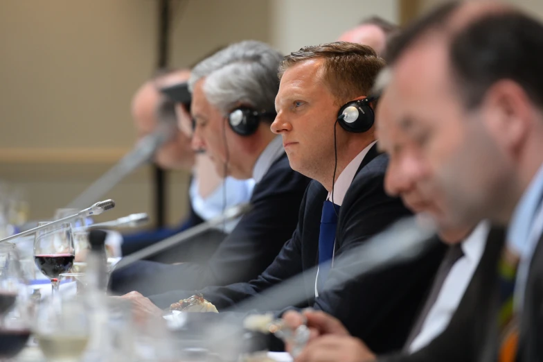 a group of men in headphones listening to music