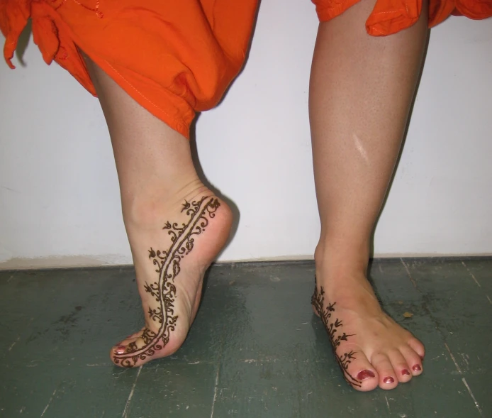 the bare feet and feet of a woman wearing orange dresses