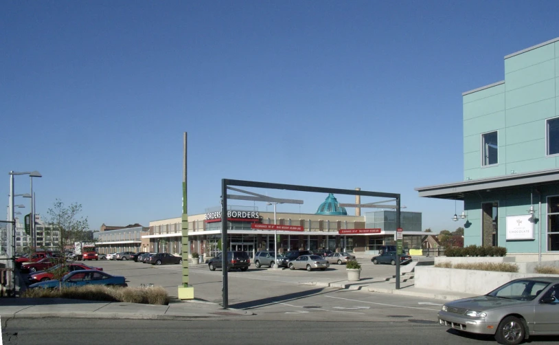 a few cars are driving by some shops