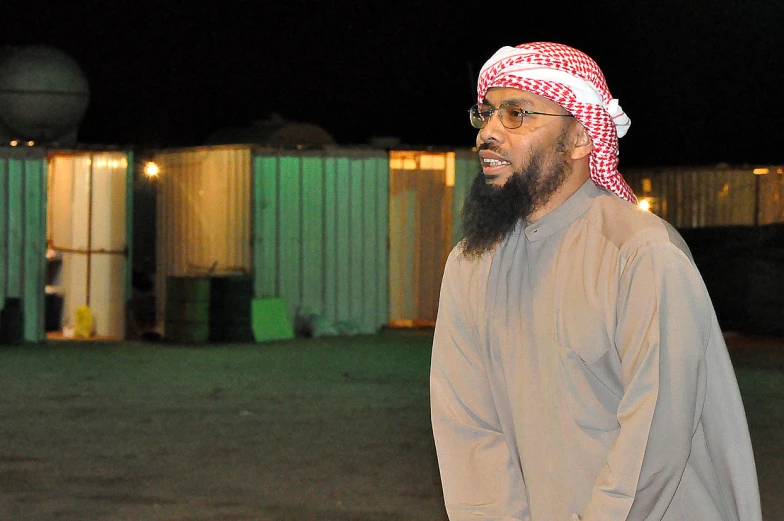 a young man with a long beard is standing outside