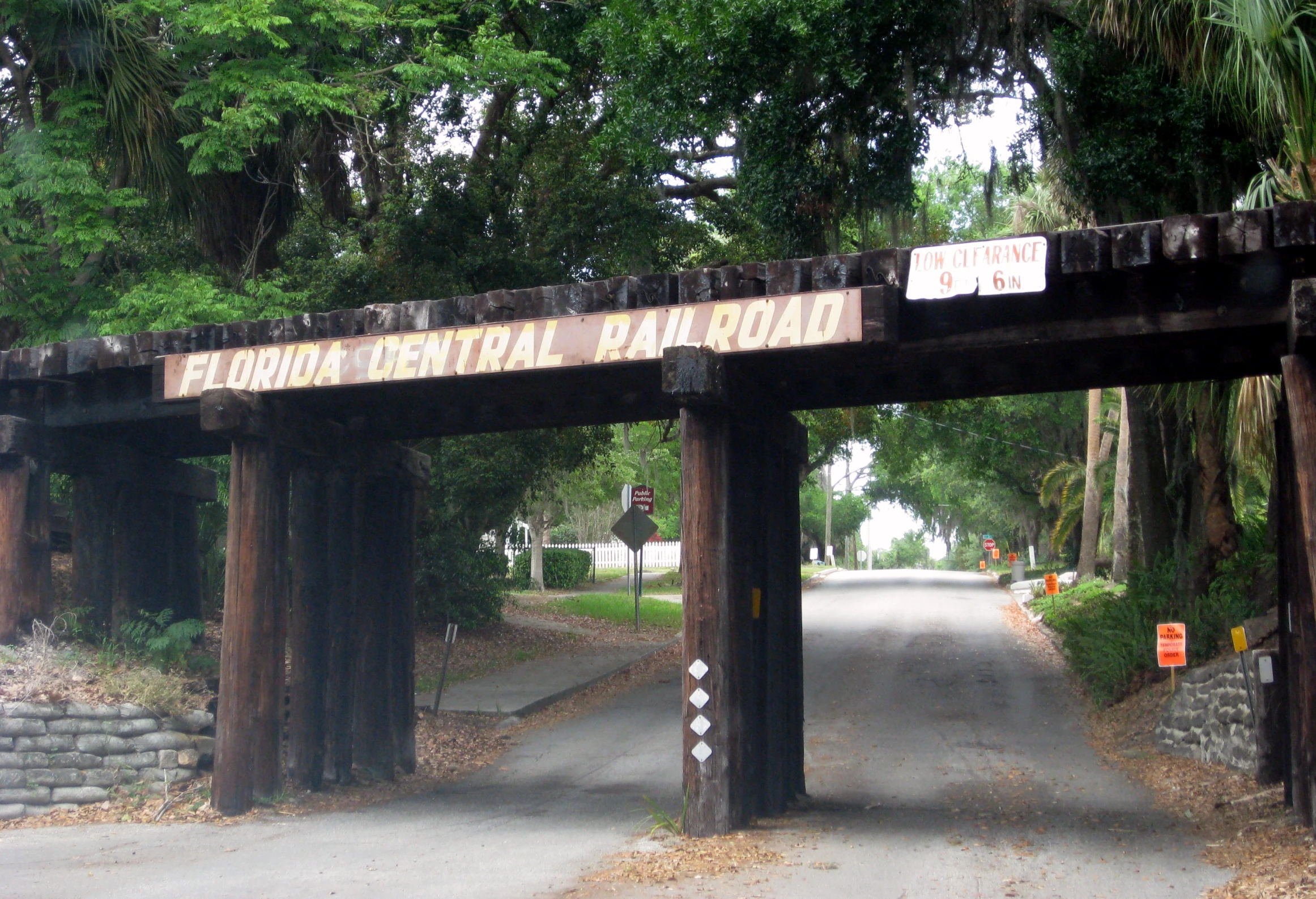 a road that has a wooden entrance sign on it