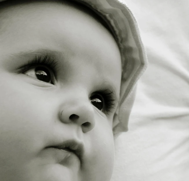 a black and white po of a baby looking at soing