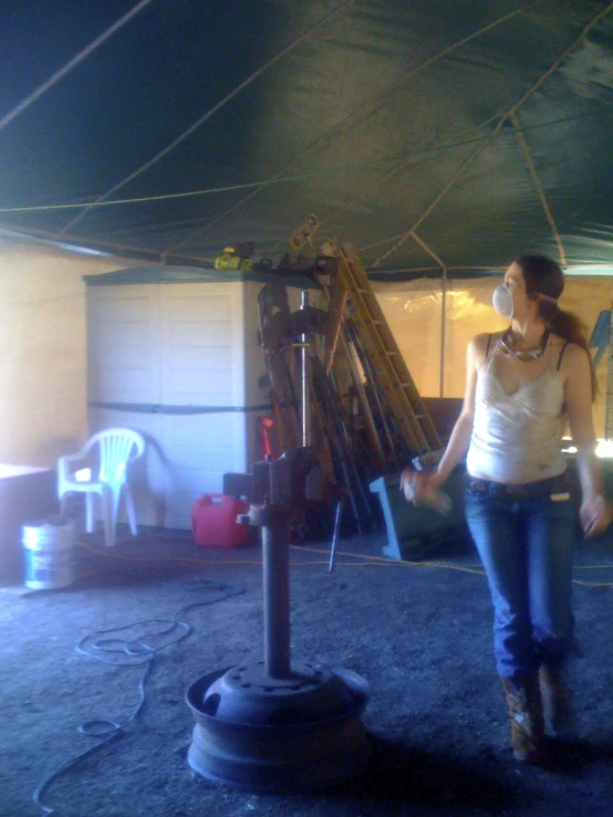 a woman standing underneath a tent wearing cowboy boots and earphones